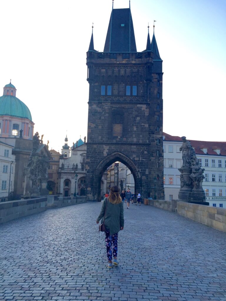 Woman standing in the middle of Charles Bridge in Prague