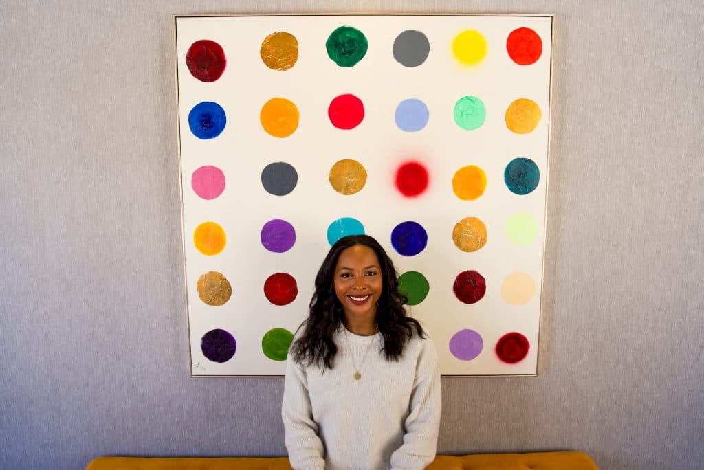 woman in front of colorful painting